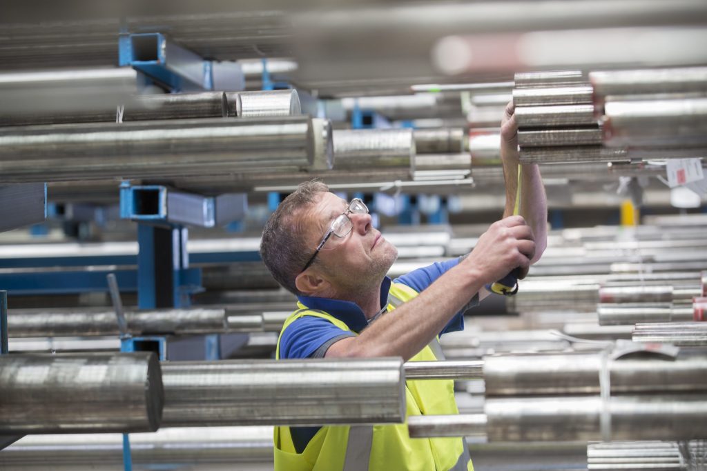 Warehouse staff checking bar stock on racking